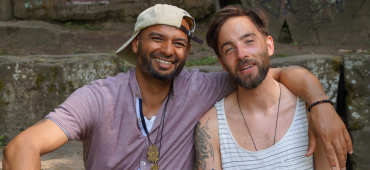 Ceddie sitzt mit Ben im sommerlichen Outfit freundschaftlich auf einer Steintreppe